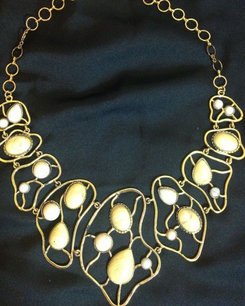 Maxi colar dourado com pedrinhas bege.